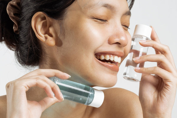 Happy Woman with Cosmetic Bottles