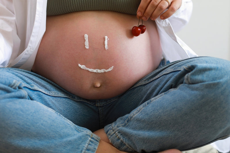 pregnant lady with moisturizing cream on belly 