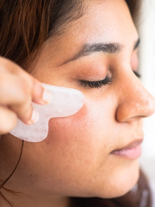 woman using rose quartz gua sha