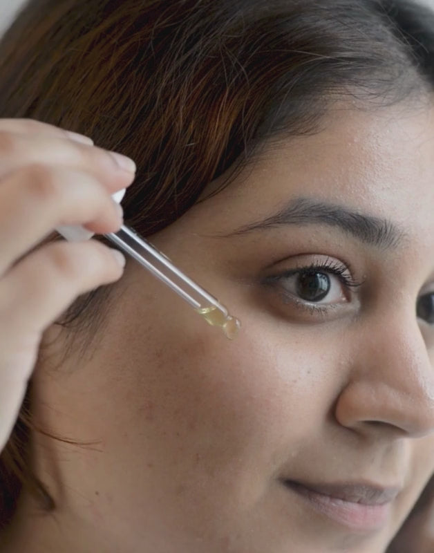 Woman Applying Facial Oil on Face