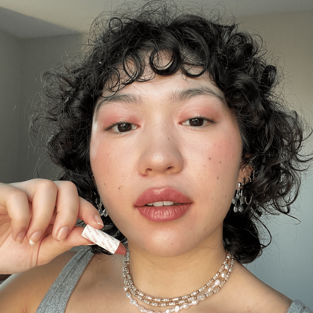 woman with light skin tone holding Rose Lip-to-Lid Balmie