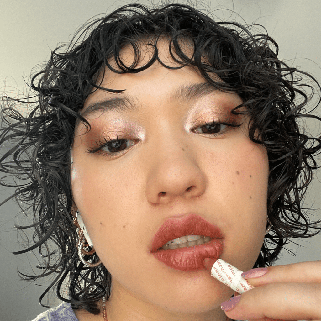 woman with light skin tone applying Cinnamon Lip-to-Lid Balmie