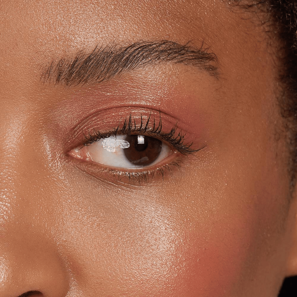 woman with dark skin tone wearing Peach Lip-to-Lid Balmie on lids