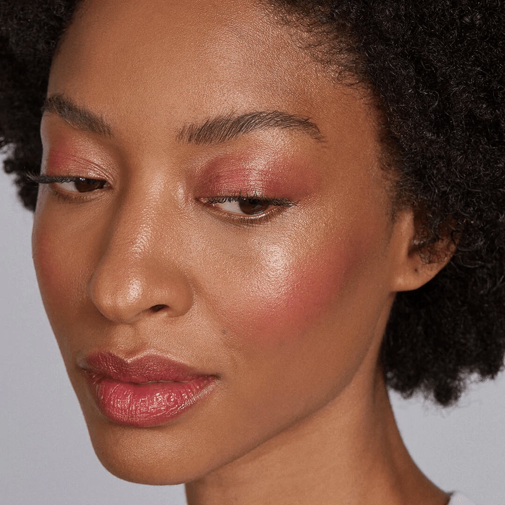 woman with dark skin tone wearing Raspberry Lip-to-Lid Balmie on eyelids and lips