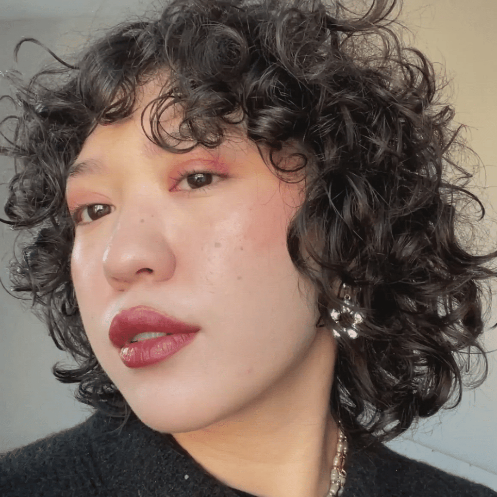 woman with light skin tone wearing Cherry + Strawberry Lip-to-Lid Balmie 