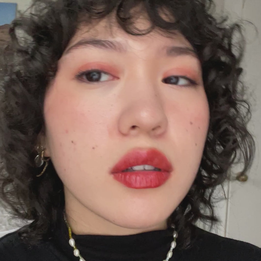 woman with light skin tone applying Cherry + Strawberry Lip-to-Lid Balmie